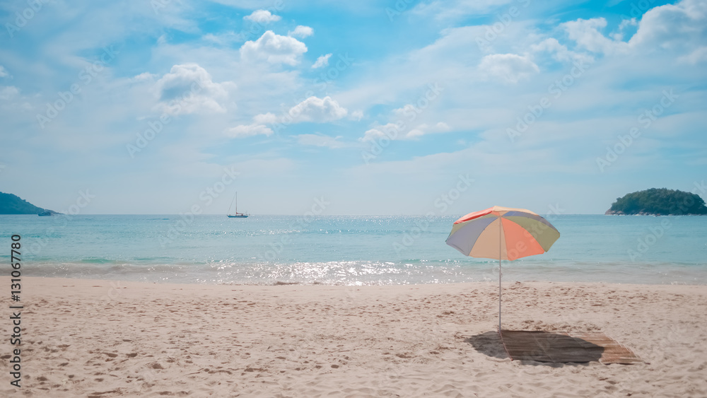 Colorful umbrella and mat on tropical beach with blue sky and white cloud abstract background.