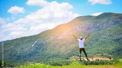 Feel good and freedom concept. Copy space of happy man jumping on top of mountain.