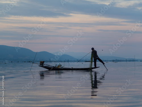 Unrecognizable fishermen in sunrise at Lake Inle