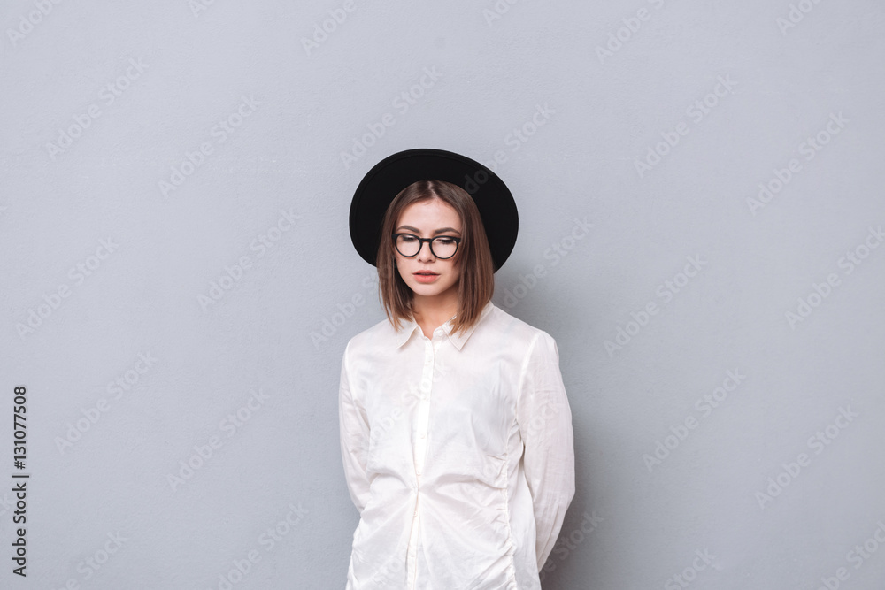 Portrait of a casual girl wearing hat and eyeglasses standing Portrait of a casual girl wearing hat and eyeglasses standing