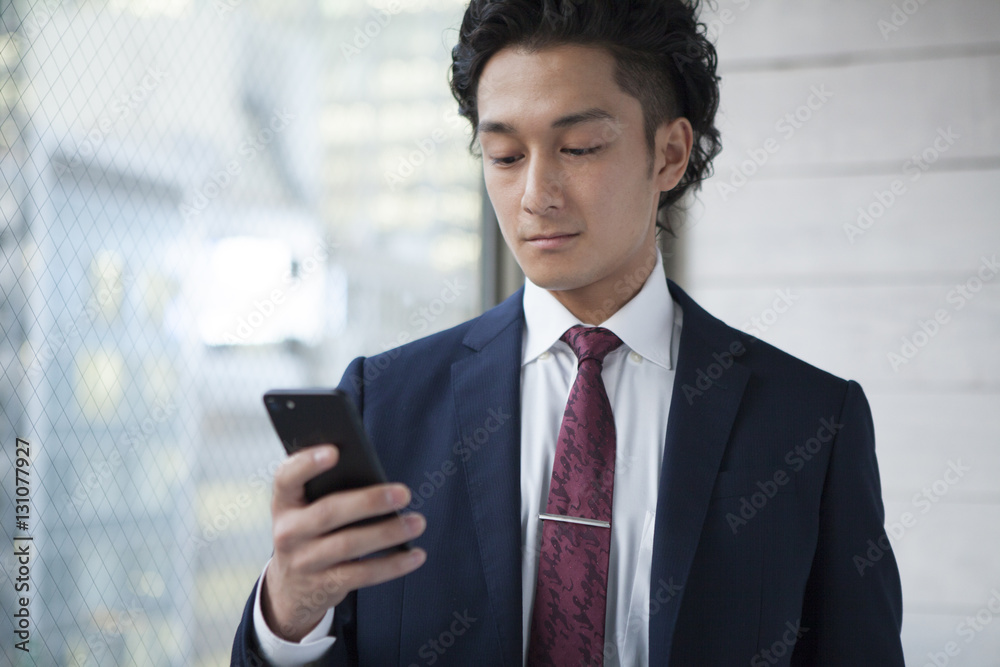 Businessman, looking at a smartphone in the office Businessman, looking at a smartphone in the office