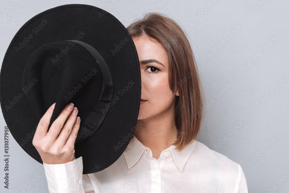 Woman covering half of her face with hat Woman covering half of her face with hat