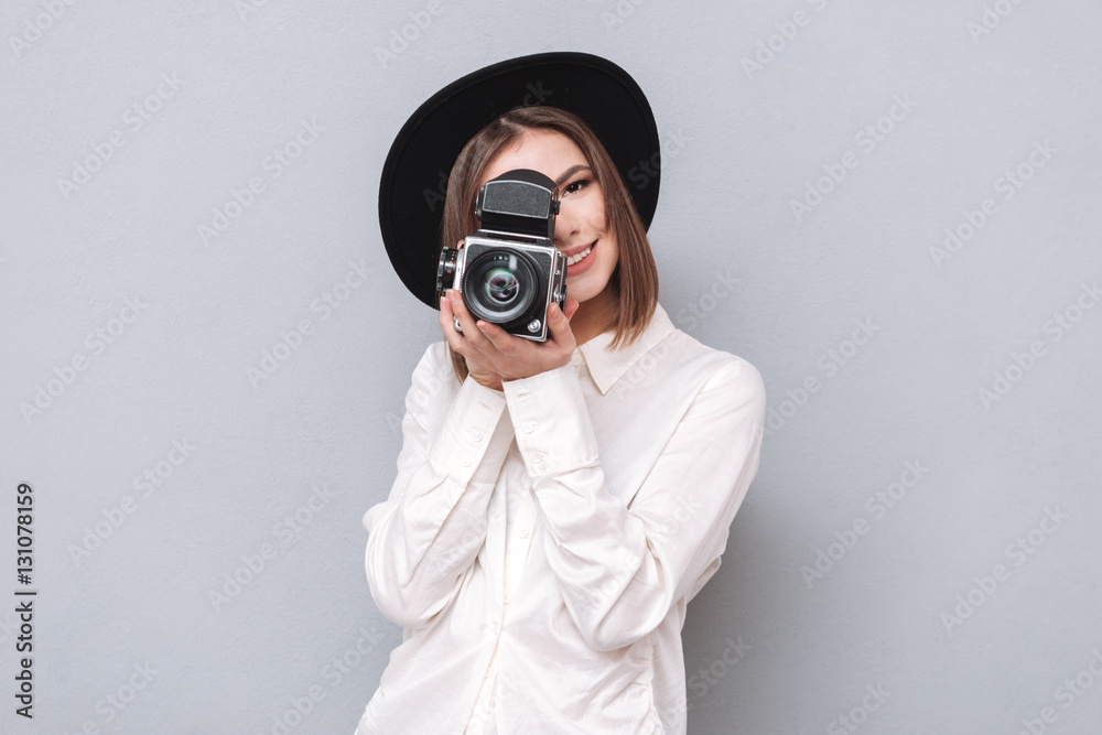 Portrait of a young smiling woman filming with retro camera Portrait of a young smiling woman filming with retro camera