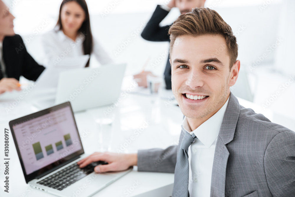 Portrait of business man by the table with colleagues Portrait of business man by the table with colleagues