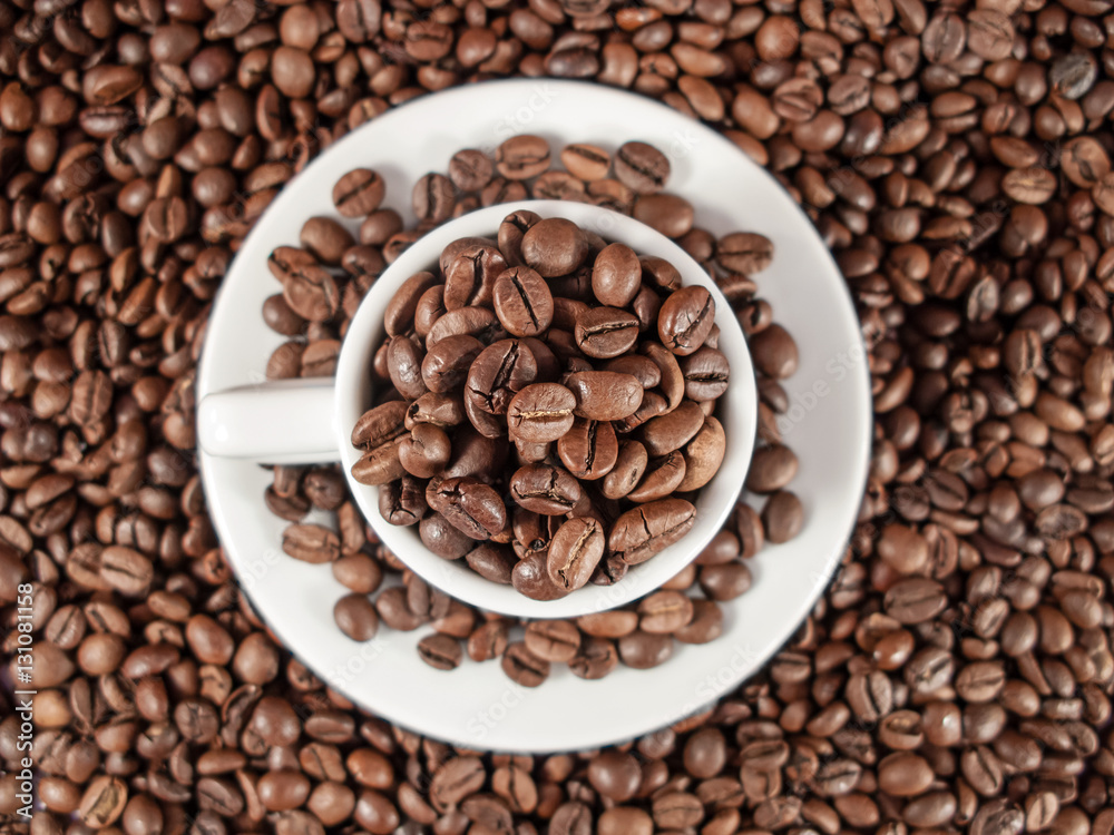 Background texture of coffee beans and a white espresso cup. Background texture of coffee beans and a white espresso cup.