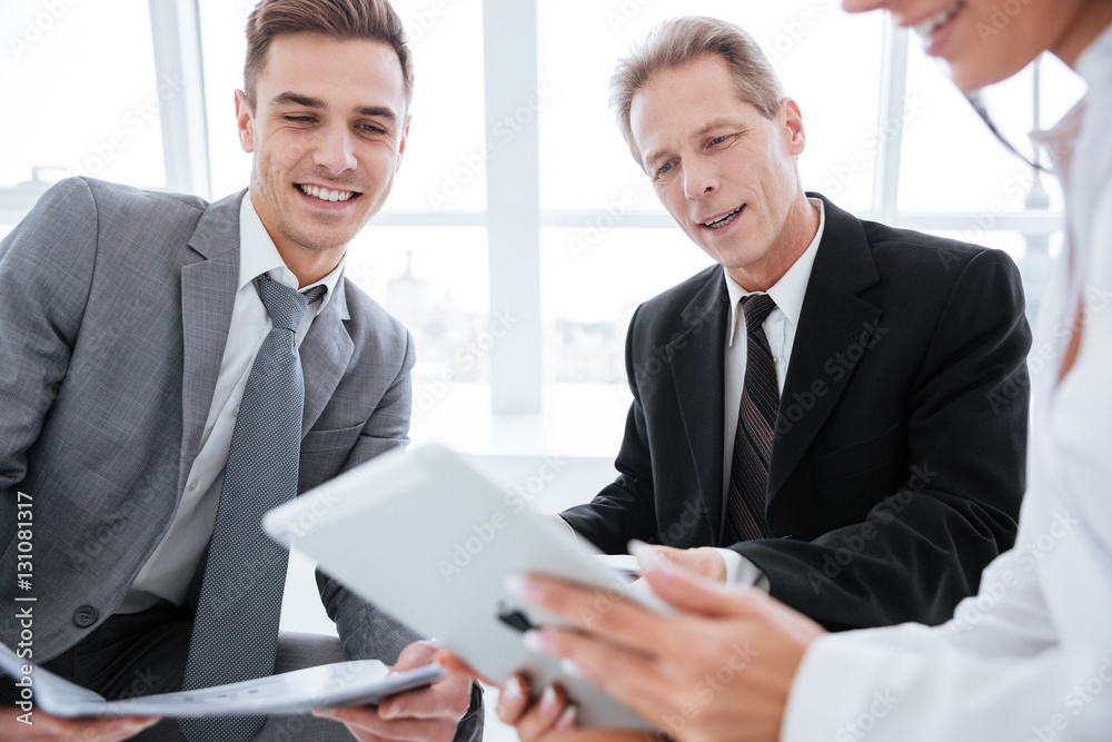 Fototapeta premium Cropped image of three business people with tablet
