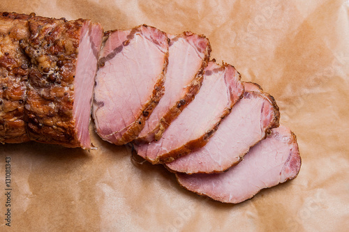 Close up view of sliced smoked meat or ham on brown packing pape