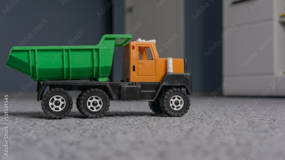 Truck - toy for a boy on the carpet