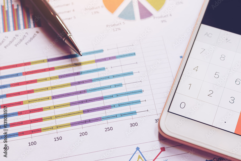 Data analyzing with calculator in smart phone and pen on charts Data analyzing with calculator in smart phone and pen on charts
