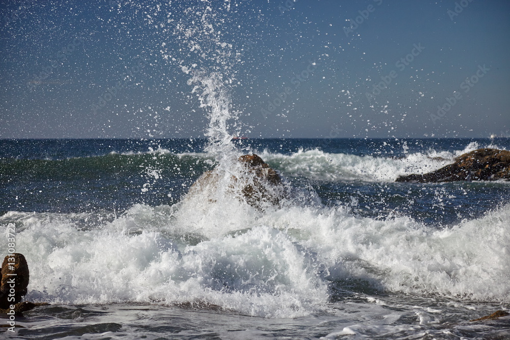 splits waves against rocks in the sea