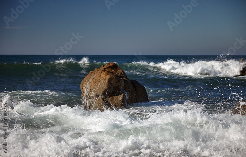 splits waves against rocks in the sea