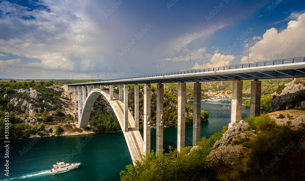 Boat traveling to yacht club docks passing under the Bridge which is Over Krka