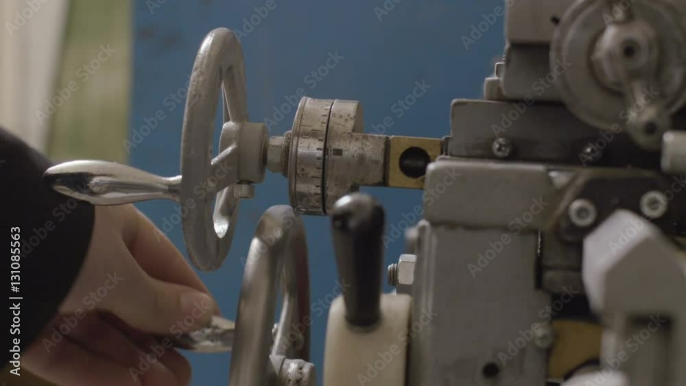 Worker controls adjustment wheel of lathe machine Worker controls adjustment wheel of lathe machine