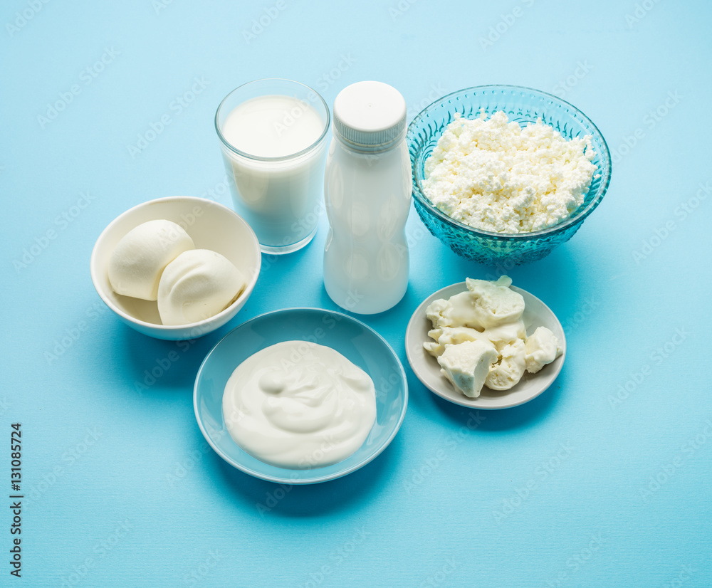 Protein products: cheese, cream, milk, eggs on the blue backgrou Protein products: cheese, cream, milk, eggs on the blue backgrou