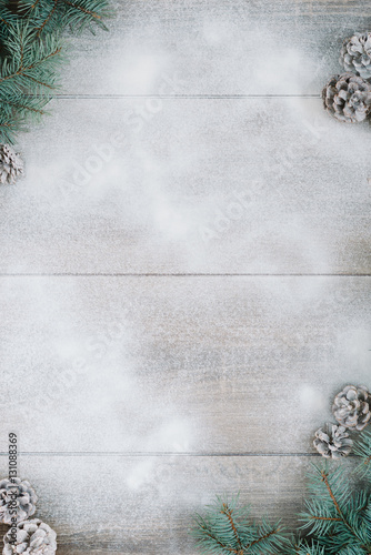 Christmas decorations, pine needles and cones on white wooden background