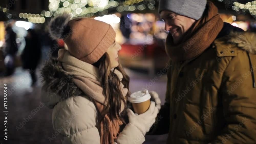 happy couple with coffee at christmas market happy couple with coffee at christmas market