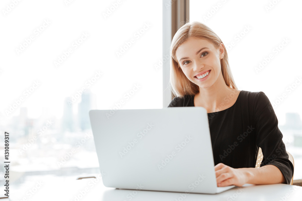 Cheerful young lady worker using laptop computer Cheerful young lady worker using laptop computer