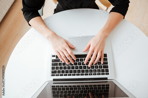Top view photo of young lady using laptop computer