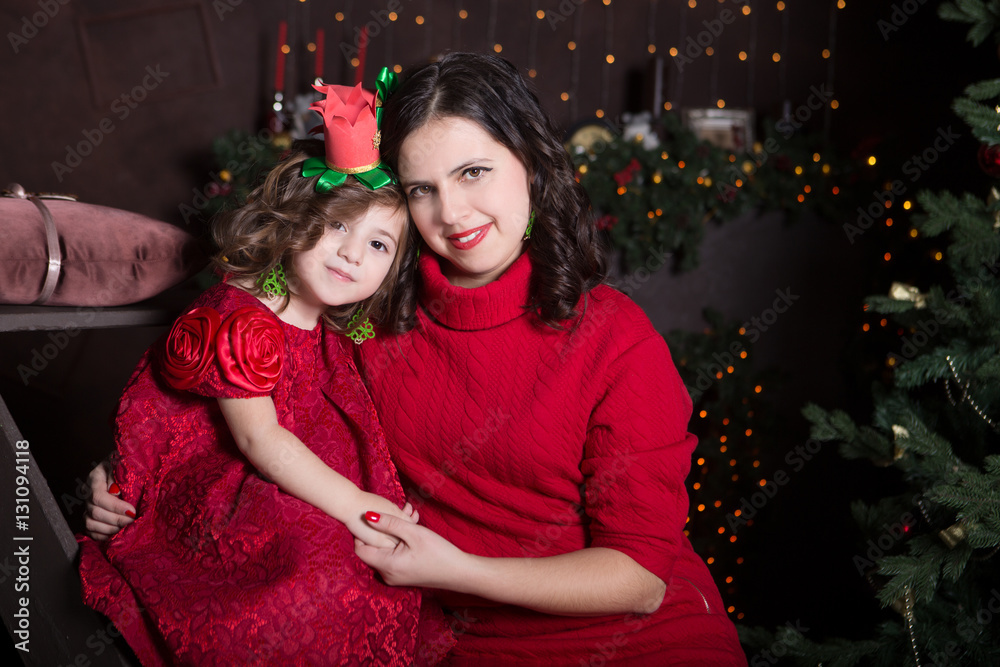 happy family mother and daughter in red dress hugging in the home on Christmas eve. Family look
happy family mother and daughter in red dress hugging in the home on Christmas eve. Family look