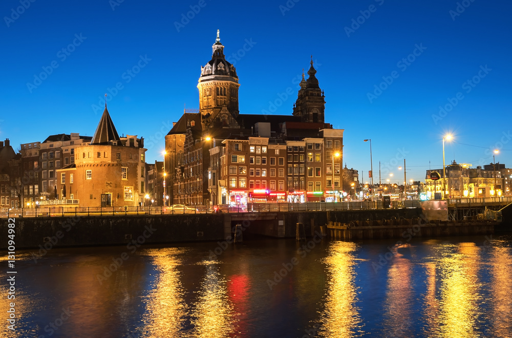 View of the city with Church of St.Nicholas and Schreierstoren at night during Amsterdam Light Festival, The Netherlands