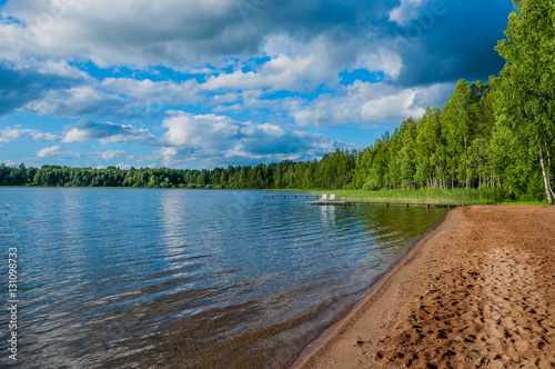 Fototapeta Naklejka Na Ścianę i Meble -  Waterfront and sandy beach beautiful forest lake in a secluded location for escape, unplugged