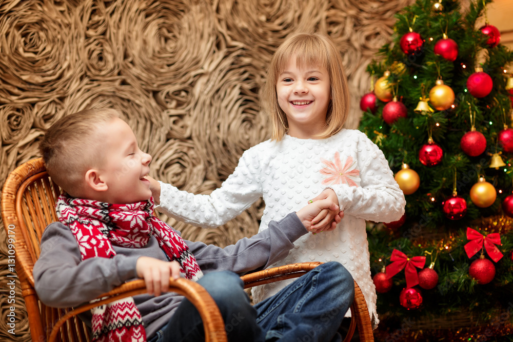 two small children in the background of the Christmas tree two small children in the background of the Christmas tree