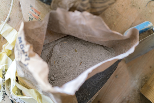 Opened bag of dry cement viewed from above on a building site in a construction or renovation concept