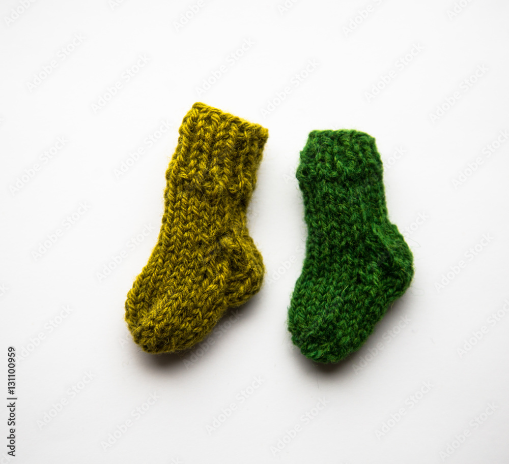 Fototapeta premium Small, hand knitted woolen socks on light background