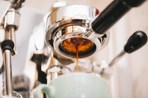 Fresh morning espresso coffee pouring through the bottomless portafilter