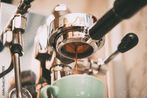 Photo Fresh morning espresso coffee pouring through the bottomless portafilter