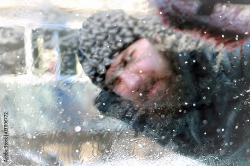 man cleans snow from the glass at the car