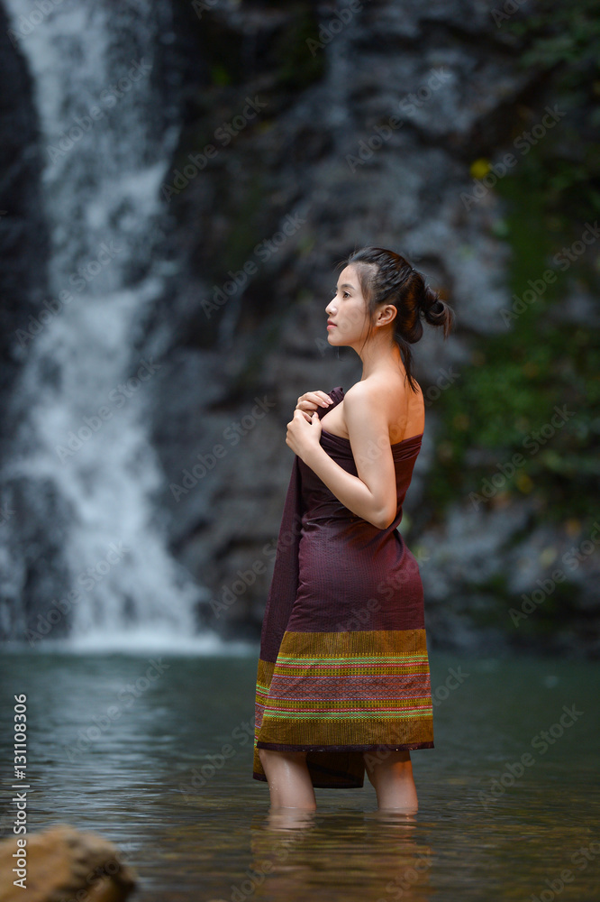 Fototapeta premium Asian woman wearing traditional thai take a baht on during sunset,vintage style,Beautiful woman take a baht,woman take a baht in river,Woman thai culture
