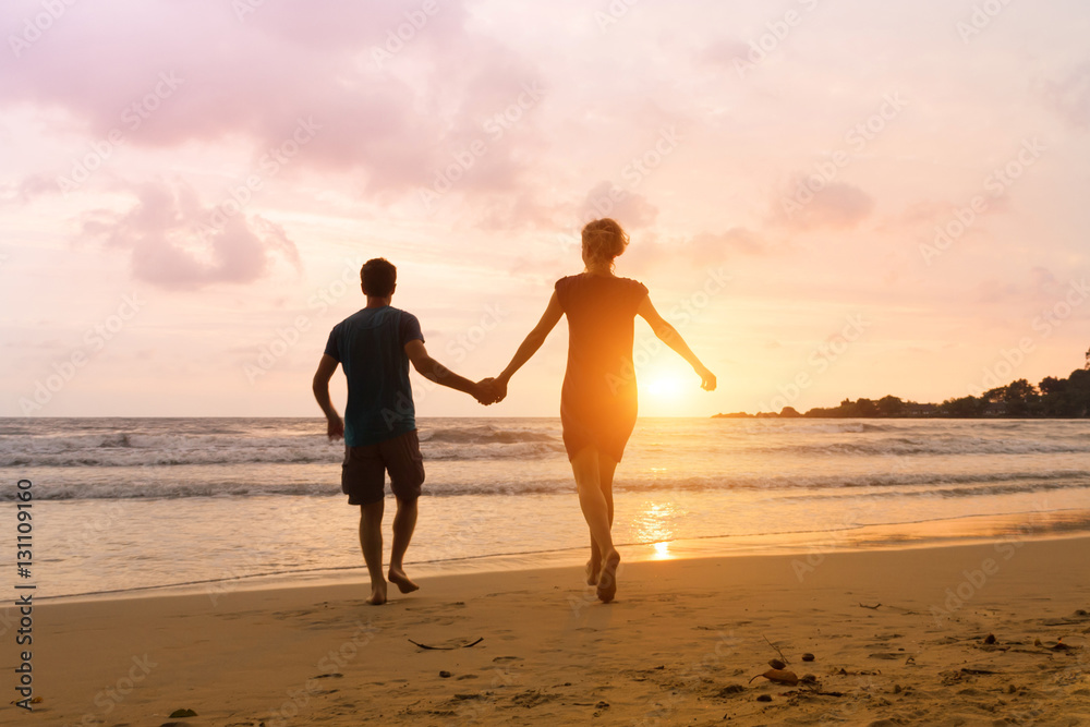 Romantic carefree couple running to the sun at sunset sea beach. Vacation of dream, travel to Thailand