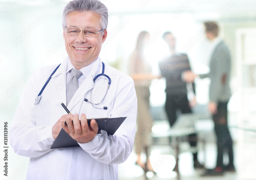 Happy smiling mature doctor writing on clipboard Happy smiling mature doctor writing on clipboard