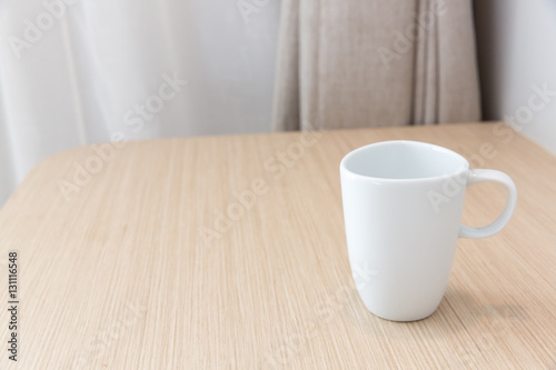 White cups on wooden bar table in bed room with blank space for text
