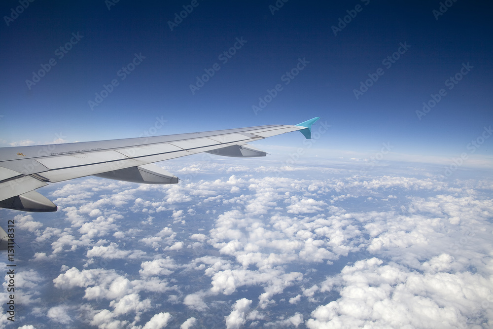 Wing of an airplane flying above the clouds Wing of an airplane flying above the clouds