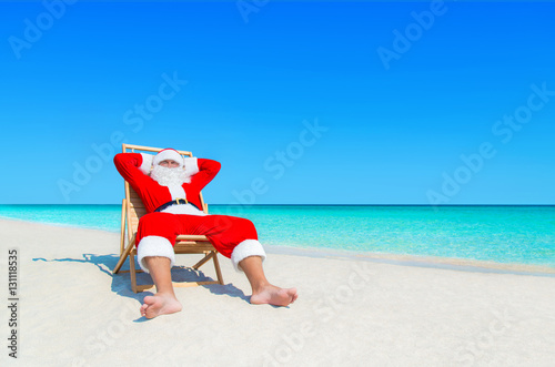 Santa Claus relax in sunlounger at sandy tropical sea beach
