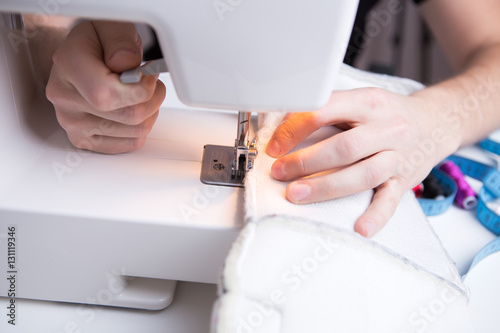 Young girl stitching white cloth