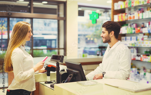 Experienced pharmacist counseling female customer in modern phar photo