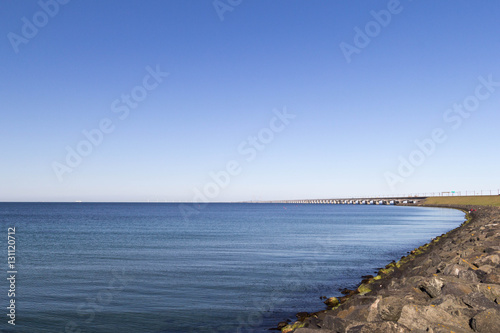 The sea shore overlooking the long white bridge © Kseniia