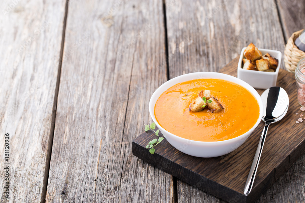 Pumpkin carrot soup on wooden background Pumpkin carrot soup on wooden background