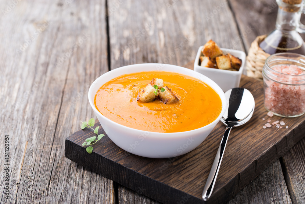 Pumpkin carrot soup on wooden background Pumpkin carrot soup on wooden background