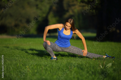 Young woman lunges toward the grass looking down