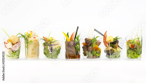 Mini desserts and meat canapes vegetable snacks in plastic cups canaps photo