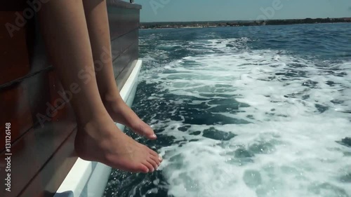 dangling feet off of cruising boat