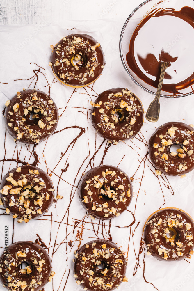 Fresh baked gluten free chocolate donuts and bowl with glaze Fresh baked gluten free chocolate donuts and bowl with glaze