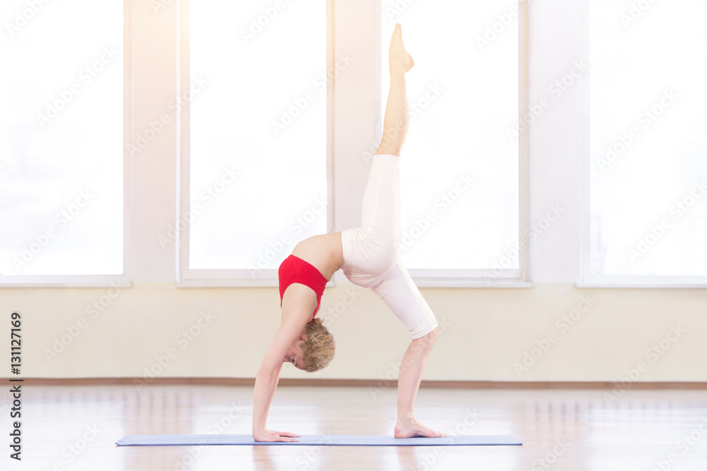 Young woman in white doing yoga pose