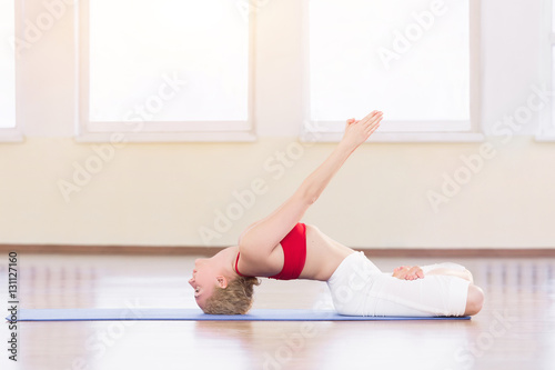 Young woman in white doing yoga pose