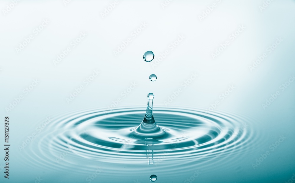 Water drop falling and drips on water mirror. Drops splash and make perfect circles on water surface Water drop falling and drips on water mirror. Drops splash and make perfect circles on water surface