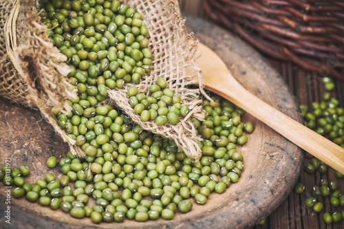 Raw mung beans (Vigna radiata) spilling from burlap bag